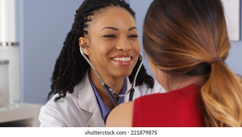 Close up of African American physician listening to heart and lungs of patient