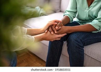 Close up African American psychotherapist holding clipboard, touching patient hands, expressing empathy and support at meeting, counselor therapist comforting girl during personal therapy session - Powered by Shutterstock