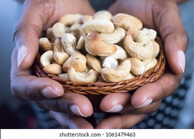 Close Up African American Woman Dark Brown Skin Hands Holding A Basket With Cashew Nuts. Healthy Food And Snack For Healthy Eating And Oils Concept