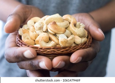 Close Up African American Woman Dark Brown Skin Hands Holding A Basket With Cashew Nuts. Healthy Food And Snack For Healthy Eating And Oils Concept