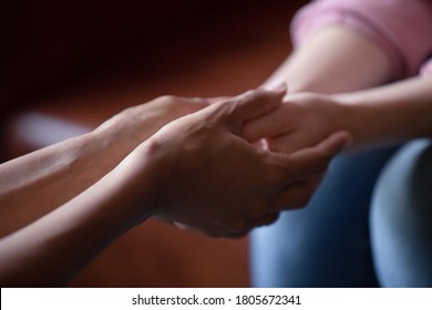 Close up African American woman psychologist counselor comforting depressed girl patient at meeting, holding hands, expressing support, understanding and care, personal therapy session - Shutterstock ID 1805672341