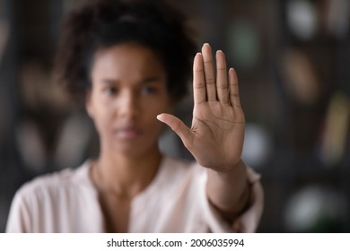 Close up of African American woman showing stop gesture with hand blurred background, young female protesting against domestic violence and abuse, bullying, saying no to gender discrimination - Shutterstock ID 2006035994