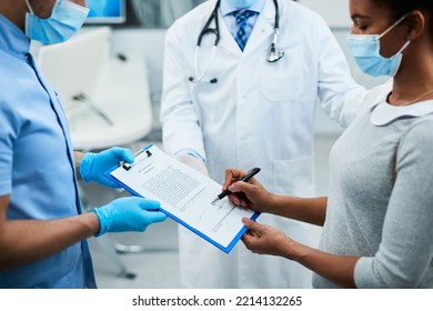 Close Up Of African American Woman Signing An Agreement At Dental Clinic During Coronavirus Pandemic.