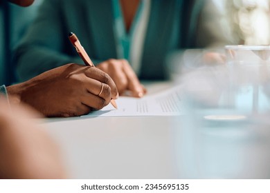 Close up of African American woman signing a contract with bank manager in the office. - Powered by Shutterstock