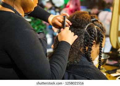 Close up african hairstylist braided hair of afro american female client in the barber salon. Black healthy hair culture and Style. Stylish therapy professional care concept. Selective focus
