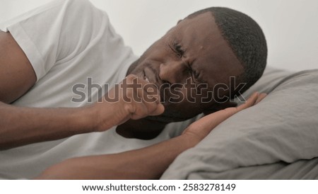 Close up of African Man Coughing while Lying on Side in Bed