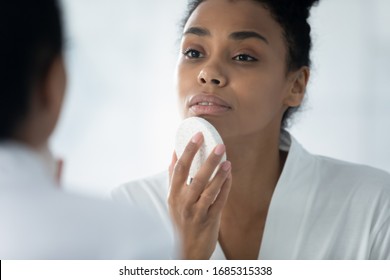 Close up African woman do evening routine cleanses skin using natural facial sponge, gently remove dirt, beauty tool helps renew revitalize skin, keep face perfect, massage procedure, skincare concept - Powered by Shutterstock