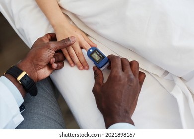 Close Up Of African-American Doctor Checking Oxygen Levels Of Child In Hospital Using Oximeter, Copy Space