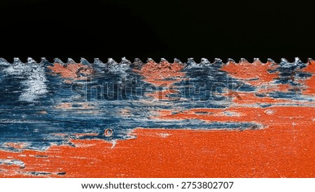 Close up of an aged saw blade with sharp teeth, exhibiting distressed textures from peeling red and blue paint over rusted metal. Photography, no generative ai