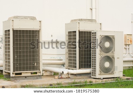 Close up Air conditioning out door, A group of three industrial sized air conditioners along a brick wall, Air conditioning with extra door for maintenance