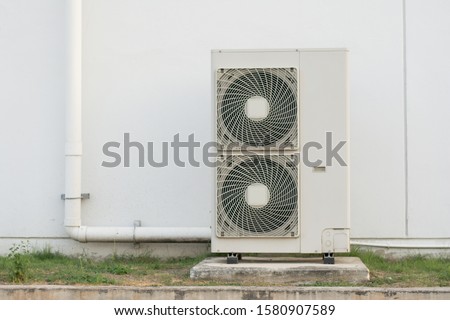 Close up Air conditioning out door,A group of three industrial sized air conditioners along a brick wall,Air conditioning with extra door for maintenance