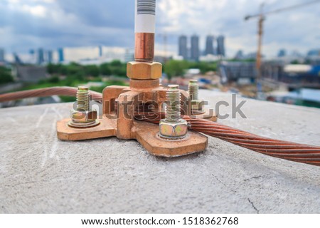 Close up Air terminal rod and bare copper cable install on rooftop of high building for Lightning protection and protect electrical equipment damage when raining and lightning strike. Selective focus.