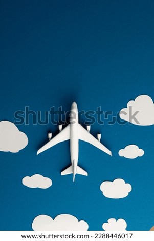 Close up of airplane model with clouds on blue background with copy space. Travel, transport and vacation.