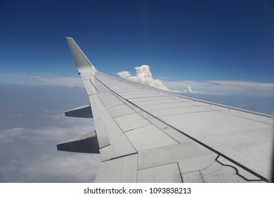  Close up airplane wing while plane in blue sky                                 