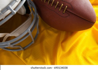 Close Up Of American Football And Helmet On Yellow Jersey