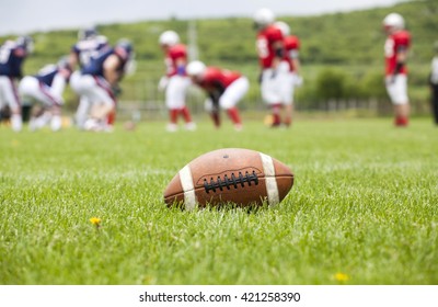 Close Up Of An American Football On The Field, Players In The Background