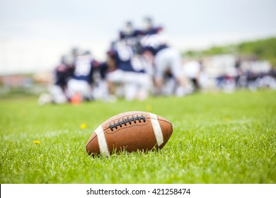 Close Up Of An American Football On The Field, Players In The Background