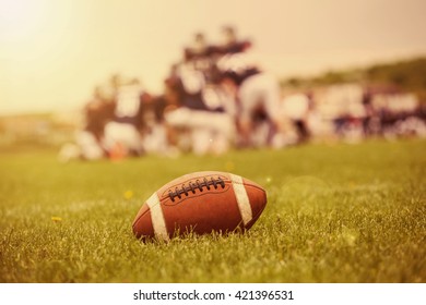 Close Up Of An American Football On The Field, Players In The Background