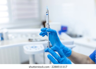 Close up of anesthesia syringe in the hands of a dentist doctor. Anesthetist dentist doctor holds in his hand anesthesia syringe prior to dental surgery. Hand in a rubber glove