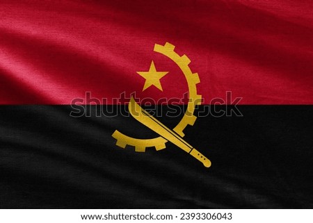Close up of the Angola flag. Angola flag of background. Flag of Angolan. Angola flag with big folds waving close up under the studio light indoors. The official symbols and colors in fabric banner