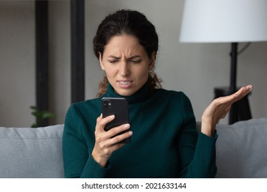 Close up angry dissatisfied woman looking at phone screen, unhappy confused young female having problem with broken smartphone or internet fraud, slow internet connection, reading bad news in message