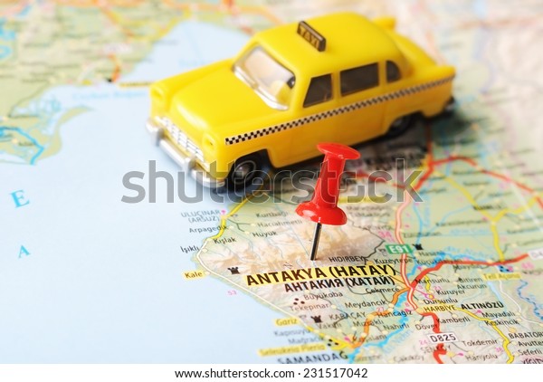 Close up of  Antakya Hatay ,Turkey  map\
with red pin  and a taxi  - Travel\
concept