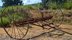 Close Of Of An Antique Hay Rake Sitting In Front Of A Lavender Field