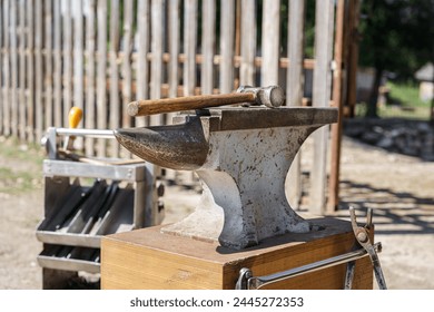 Close up of an anvil with hammer in a sunny day. Farrier tools in the background. Horseshoeing preparation is in progress. - Powered by Shutterstock