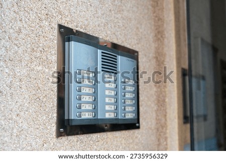 Close up of apartment intercom system mounted on building wall at entrance, access control and security device for residential property with copy space