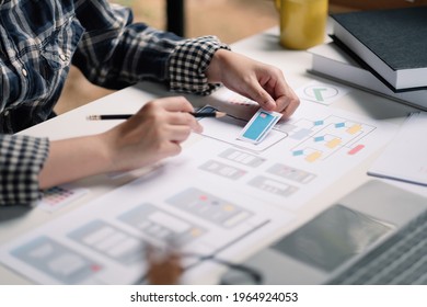 Close up App developer Ux Ui designing with paper model on mobile application prepare,