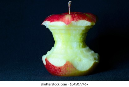 A Close Up Of An Apple Core Against A Black Background