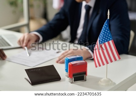 Close up of approved and rejected stamps on table in US immigration office with flag, copy space