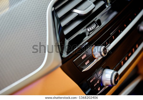 Close up of\
ar interior details of luxury sports sedan. Center dashboard\
console with multimedia player, audio system controller, climate\
control and center air vent. Selective\
focus.