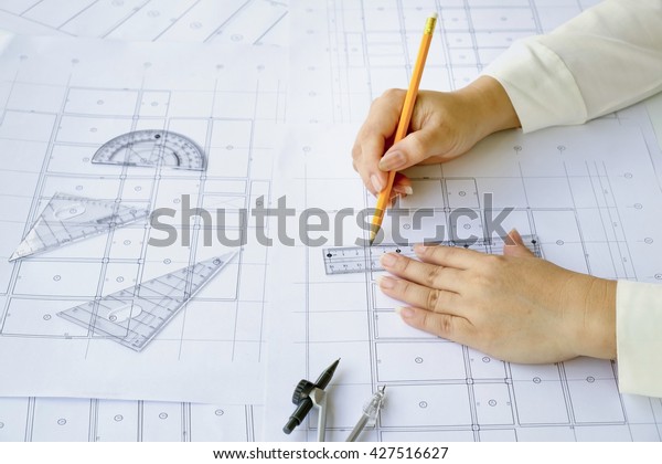 Close\
up Architect working on blueprint. Architects workplace ,\
architectural  working of Architect sketching a construction\
project on his plane project. Construction\
concept