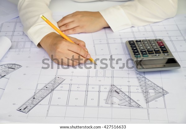 Close up Architect working on\
blueprint. Architects workplace,architectural  working of Architect\
sketching a construction project on his plane project. Construction\
concept. Engineering\
tools