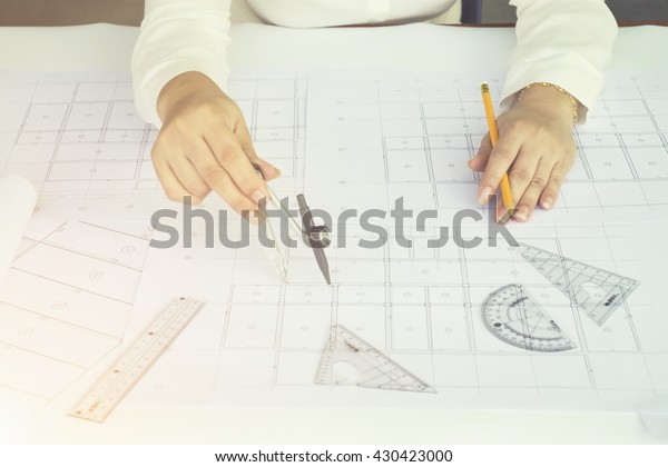 Close\
up Architect working on blueprint. Architects workplace ,\
architectural  working of Architect sketching a construction\
project on his plane project. Construction\
concept