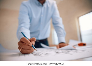 Close up of architect writing blueprints during housing development project. - Powered by Shutterstock