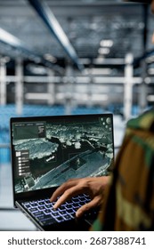 Close up of army expert in data center supporting mission operations with aerial surveillance tools. Military man in server room checking ballistic missiles movement on reconnaissance feed