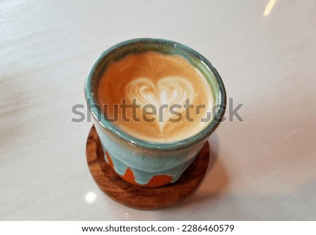 Close up Aromatic Cappucino Coffee Latte Arabica Robusta Mix with Love Latte Art . Hot coffee drink for breakfast 