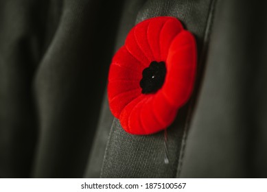 Close Up Of Artificial Poppy Flower On Coat Lapel For Remembrance Day.