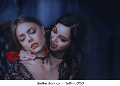 Close Up artwork portrait face sexy vampire woman bites eating drinks young princess. Makeup Drop blood. Bloody wounds bite on neck blonde girl. Horror night halloween. Holiday scary make-up red lips 