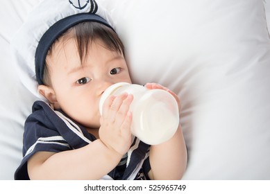 Close up of Asian baby infant drinking mother breast feeding from bottle 