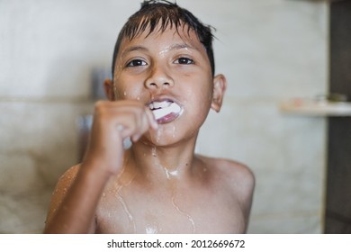 Close up of asian boy brushing teeth with foam coming out of his mout