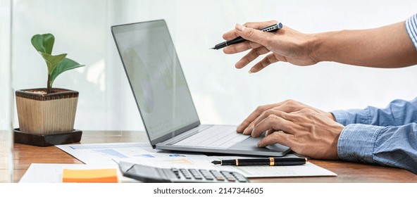 Close up of asian business woman pointing on laptop screen to share idea about new project business to partner while wearing protective face mask to protect coronavirus and brainstorming together - Powered by Shutterstock