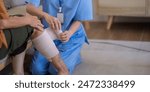 Close up of Asian caregiver bandaging elderly woman