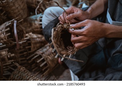 Close Up Of Asian Craftsman Hand Weaving Crafts On A Brick House Background