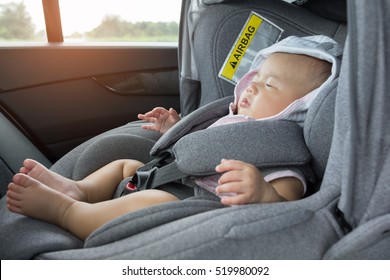 Close Up Asian Cute Newborn Baby Sleeping In Modern Car Seat. Child New Born Traveling Safety On The Road. Safe Way To Travel Fastened Seat Belts In A Vehicle With Young Kids. Trip With An Infant.