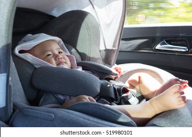 Close Up Asian Cute Newborn Baby Sitting In Modern Car Seat. Child New Born Traveling Safety On The Road. Safe Way To Travel Fastened Seat Belts In A Vehicle With Young Kids. Trip With An Infant.