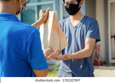 Close Up Asian Delivery Man Wearing Mask Send Food From Restaurant Protection Pandemic And Fever On Front Receiver Shipping Deliver Cargo Social Distancing While The Virus Is Spreading.