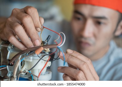 close up of asian electronics repairman fixing broken wires at an electronics repair shop - Powered by Shutterstock